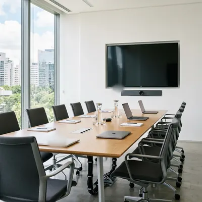 Sala de reunião corporativa com tela e barra de videoconferência instaladas